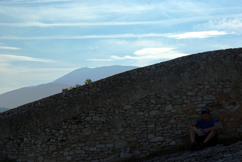 Ben reading an odd but excellent book at the top of the old city of Vaison la Romaine with the towers of Mont Ventoux in the distance. (Michel Houellebecq&#39;s the possibility of an island. Ben is finding an appropriate quote but for now - http://www.goodreads.com/author/quotes/32878.Michel_Houellebecq )